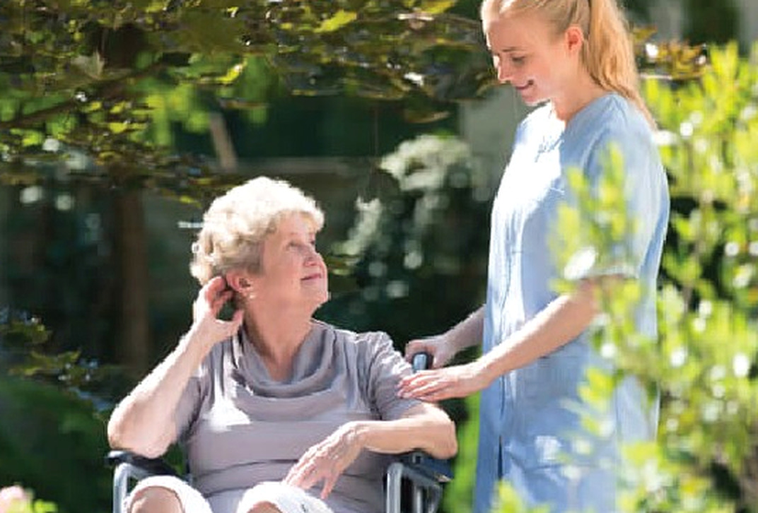 Caregiver talking with an older adult outdoors